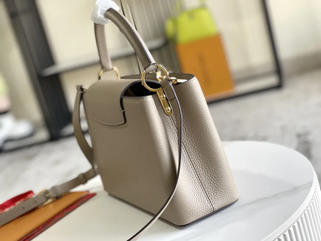 (163 芯片)特级配全套包装💰P1050【特级精品原厂皮💋 M94428 大象灰中号金扣】 第一家路易威登门店开在巴黎的嘉布遣街上,Capucines手袋与品牌一样经久不衰,可以为任何造型带来时尚的精致感。全粒面Taurillon皮与稀有宽纹蟒蛇皮结合,打造出一款奢华的手提包,各种传统的细节是手袋的亮点:LV首字母,独特的边环,翻盖上精细的Monogram花朵。配有顶部手柄、可脱卸包带与独特包盖,多种背携风格,适应不同造型或心情。 ♦️进口荔枝纹牛皮 ♦️原厂全钢拉丝五金 尺寸:31.5 x 20.0 x 11.0 cm