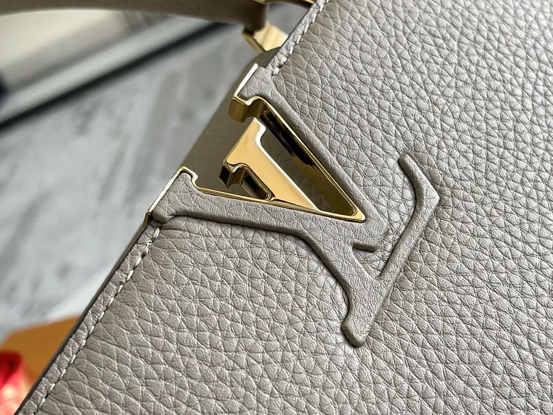 (163 芯片)特级配全套包装💰P1050【特级精品原厂皮💋 M94428 大象灰中号金扣】 第一家路易威登门店开在巴黎的嘉布遣街上,Capucines手袋与品牌一样经久不衰,可以为任何造型带来时尚的精致感。全粒面Taurillon皮与稀有宽纹蟒蛇皮结合,打造出一款奢华的手提包,各种传统的细节是手袋的亮点:LV首字母,独特的边环,翻盖上精细的Monogram花朵。配有顶部手柄、可脱卸包带与独特包盖,多种背携风格,适应不同造型或心情。 ♦️进口荔枝纹牛皮 ♦️原厂全钢拉丝五金 尺寸:31.5 x 20.0 x 11.0 cm