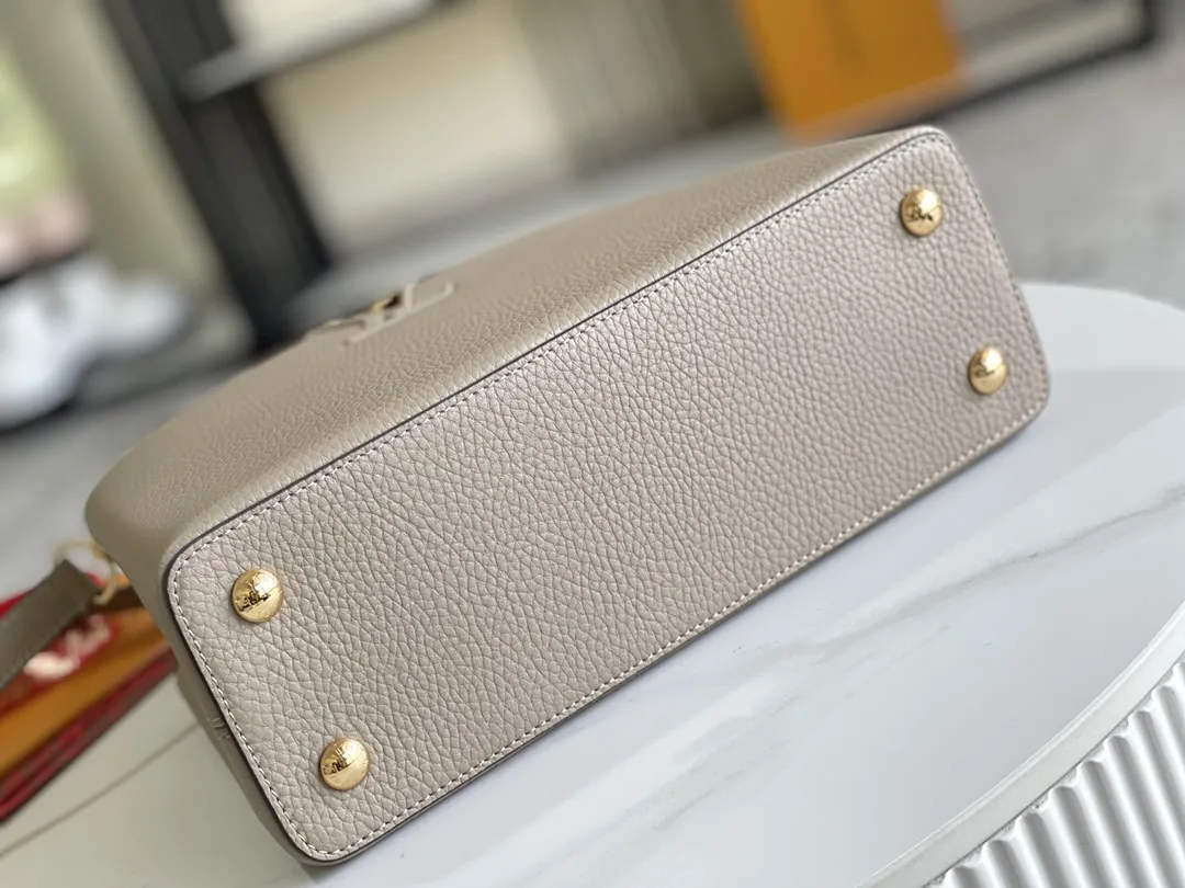 (163 芯片)特级配全套包装💰P1050【特级精品原厂皮💋 M94428 大象灰中号金扣】 第一家路易威登门店开在巴黎的嘉布遣街上,Capucines手袋与品牌一样经久不衰,可以为任何造型带来时尚的精致感。全粒面Taurillon皮与稀有宽纹蟒蛇皮结合,打造出一款奢华的手提包,各种传统的细节是手袋的亮点:LV首字母,独特的边环,翻盖上精细的Monogram花朵。配有顶部手柄、可脱卸包带与独特包盖,多种背携风格,适应不同造型或心情。 ♦️进口荔枝纹牛皮 ♦️原厂全钢拉丝五金 尺寸:31.5 x 20.0 x 11.0 cm