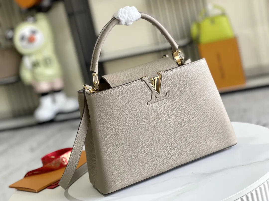 (163 芯片)特级配全套包装💰P1050【特级精品原厂皮💋 M94428 大象灰中号金扣】 第一家路易威登门店开在巴黎的嘉布遣街上,Capucines手袋与品牌一样经久不衰,可以为任何造型带来时尚的精致感。全粒面Taurillon皮与稀有宽纹蟒蛇皮结合,打造出一款奢华的手提包,各种传统的细节是手袋的亮点:LV首字母,独特的边环,翻盖上精细的Monogram花朵。配有顶部手柄、可脱卸包带与独特包盖,多种背携风格,适应不同造型或心情。 ♦️进口荔枝纹牛皮 ♦️原厂全钢拉丝五金 尺寸:31.5 x 20.0 x 11.0 cm